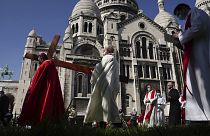Archbishop Michel Aupetit, left, carries the holy cross at the Way of the Cross ceremony as part of the Holy Easter celebration, in the Sacre Coeur basilica, in Paris, France.