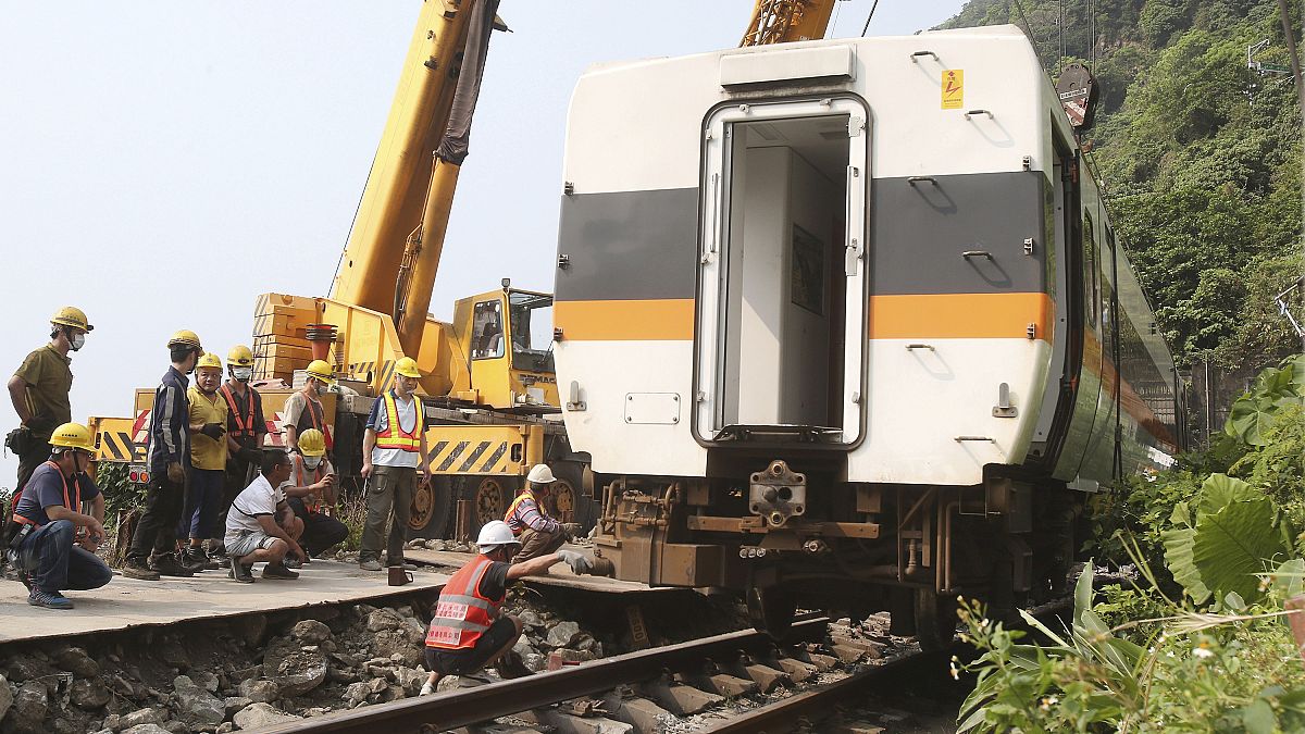 Workers try to remove a part of the derailed train near Taroko Gorge in Hualien, Taiwan 