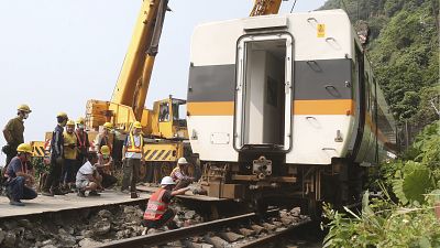 Workers try to remove a part of the derailed train near Taroko Gorge in Hualien, Taiwan