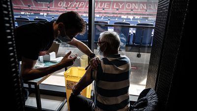 A patient receives an injection of the Moderna Covid-19 vaccine on the opening day of a mass vaccination centre set up in the OL Group's Stadium