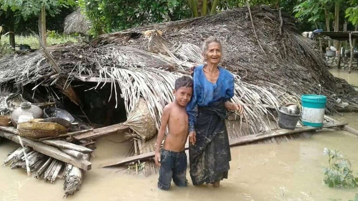 Une villageoise et son petit-fils devant leur maison endommagée dans le village de Haitimuk, en Indonésie, également touchée par les inondations le 4/04/21