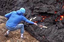 Visitor grills hot dogs on the lava of Iceland volcano.