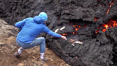 Visitor grills hot dogs on the lava of Iceland volcano.