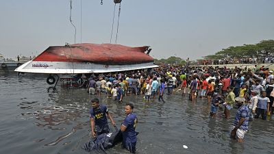 Divers carry a dead body after recovering from the capsized boat in Shitalakshya River, in Narayanganj.