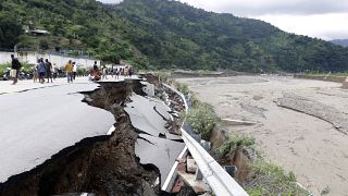 Residents inspect a damaged road following a flood in Dili, East Timor