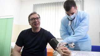 Serbian President Aleksandar Vucic, left, has his blood pressure taken before receiving a shot of the Chinese Sinopharm vaccine in the village of Rudna Glava, Serbia.