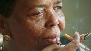 Singer Cesaria Evora, known as the "Barefoot Diva", smokes a cigarette during an interview at her home in Cape Verde in 2000.