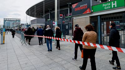 People queue as they arrive at the Stade de France stadium to be vaccinated against COVID-19 in Saint-Denis, outside Paris, Tuesday, April 6, 2021. 