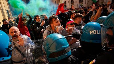 Manifestantes se enfrentan a policías italianos durante una protesta de propietarios de restaurantes y tiendas frente a la Cámara Baja en Roma, el 6 de abril de 2021