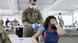  شابة أميركية تتلقى التطعيم ضد فيروس كورونا في إحدى كليات مدينة ميامي بولاية فلوريدا