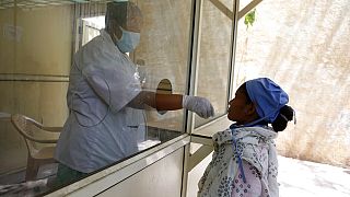 A health worker takes a swab sample to test for COVID-19 outside shopping mall in Ahmedabad, India, Saturday, April 3, 2021.