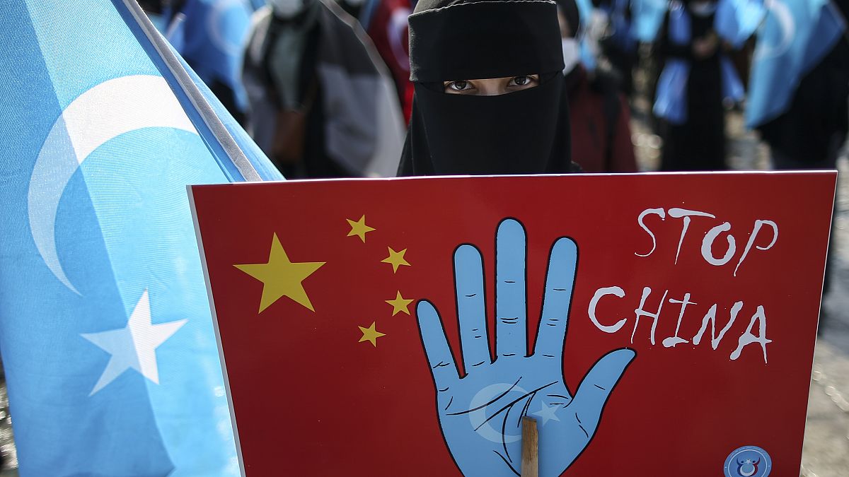 A protester from the Uyghur community holds up an anti-China placard during a protest in Istanbul.