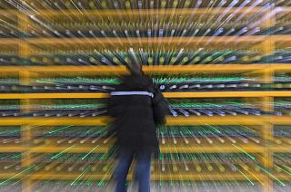 A technician inpsects the backend of a bitcoin mine.