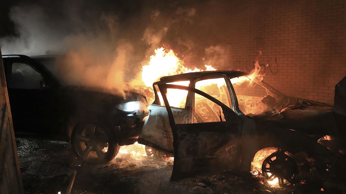 Hijacked cars burn at the peace wall on Lanark Way as rioting broke out in West Belfast, Northern Ireland. April 7, 2021.