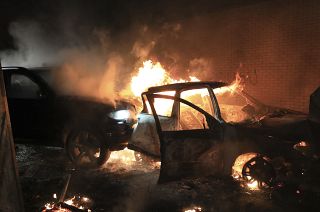 Hijacked cars burn at the peace wall on Lanark Way as rioting broke out in West Belfast, Northern Ireland. April 7, 2021.