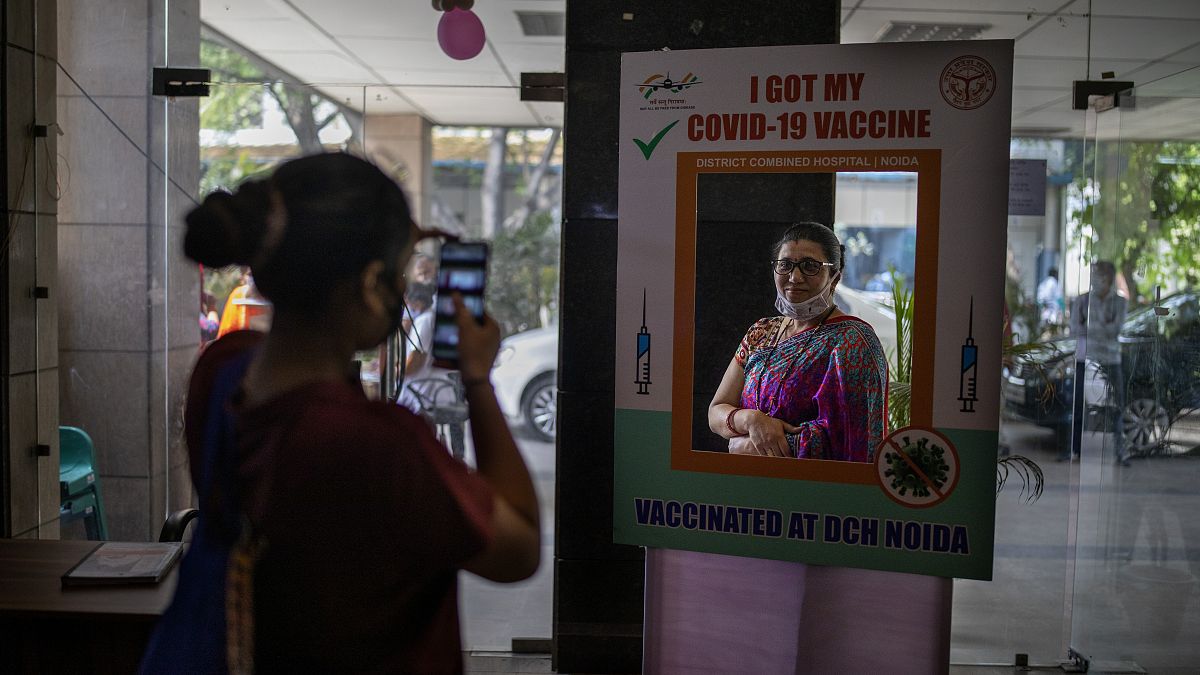 A woman poses for a photograph behind a cutout after receiving a COVID- 19 vaccine at a government hospital in Noida, a suburb of New Delhi, India, Wednesday, April 7, 2021.
