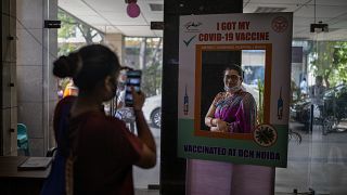 A woman poses for a photograph behind a cutout after receiving a COVID- 19 vaccine at a government hospital in Noida, a suburb of New Delhi, India, Wednesday, April 7, 2021.