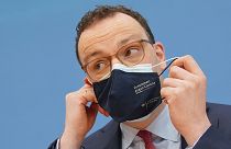 Jens Spahn, Federal Minister of Health, takes off his mouth-nose protection at the Federal Press Conference in Berlin, Germany, Thursday, April 1, 2021.