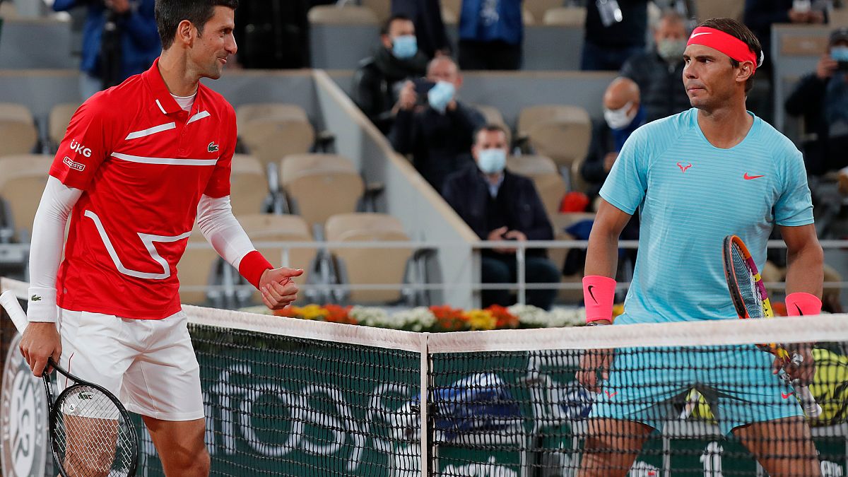Novak Djokovic, a la izquierda, y Rafael Nadal se miran antes del partido final del torneo en el estadio Roland Garros en París, Francia, el 11 de octubre de 2021.