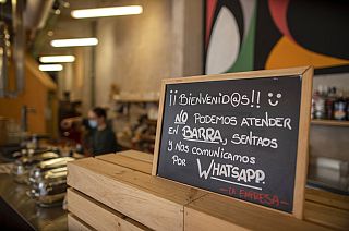 A banner reading in Spanish: "Welcome, we cannot serve in the bar. Sit down and we communicate by WhatsApp" at La Francachela restaurant in Madrid, Spain, March 26, 2021. 
