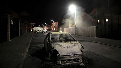Les restes d'une voiture calcinée après les heurts à Belfast (Irlande du nord), le 09/04/2021