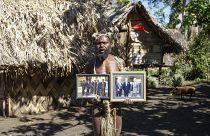 In this Sunday, May 31, 2015 file photo, Albi Nagia poses with photographs of Prince Philip in Yakel, Tanna island, Vanuatu.