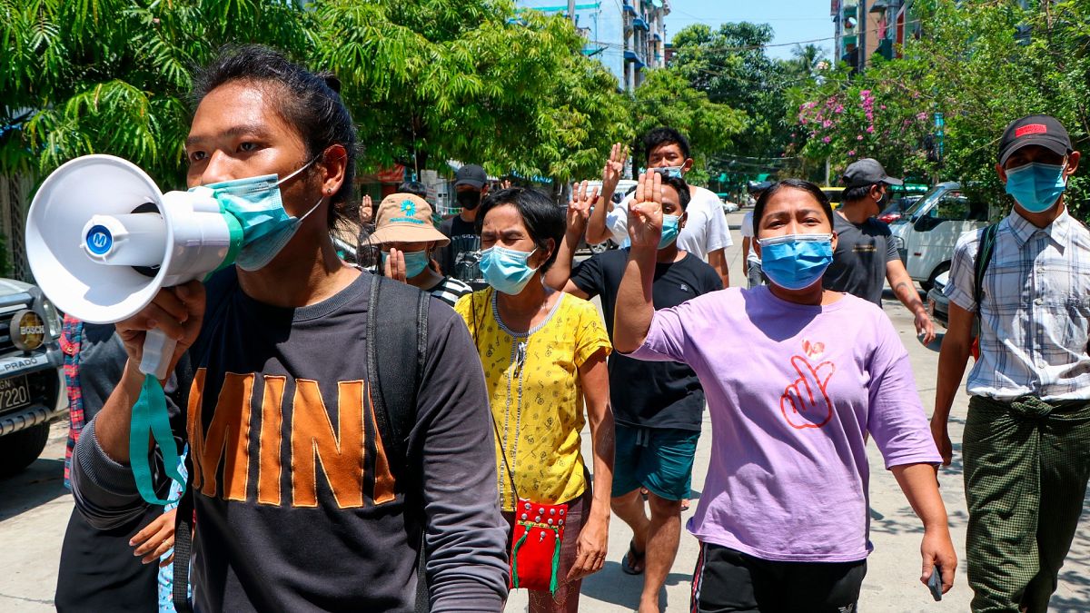 Young demonstrators flash the three-fingered symbol of resistance as they march in Yangon, Myanmar, Saturday, April 10, 2021.