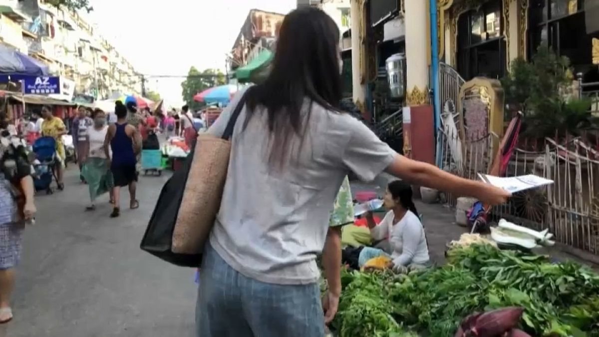 woman delivers the Molotov newsletter to people in a market