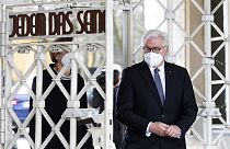 Le président allemand Frank-Walter Steinmeier franchissant le portail d'entrée du camp de concentration nazi de Buchenwald le 11 avril 2021.