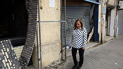 ناجية من الحرب الأهلية عبلة باروتا تسير أمام محلات تجارية تضررت في 4 أغسطس / آب 2020، في حيّها بالعاصمة اللبنانية بيروت، نيسان 2021