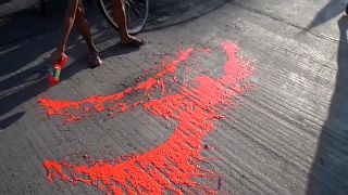 Anti-coup protestors splashing red paint on street to symbolise the blood shed by their movement