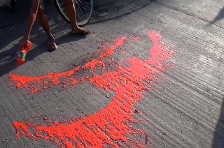 Anti-coup protestors splashing red paint on street to symbolise the blood shed by their movement