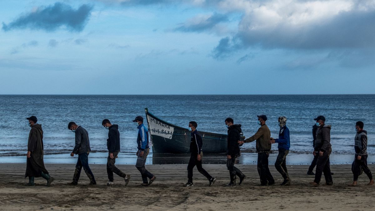 ARCHIVO, en esta foto de archivo del martes 20 de octubre de 2020, migrantes de Marruecos caminan escoltados por la Policía española tras llegar a Canarias.