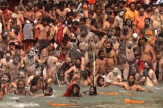Hindu pilgrims enter Ganges river to bathe during Kumbh Mela gathering