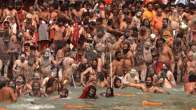 Hindu pilgrims enter Ganges river to bathe during Kumbh Mela gathering