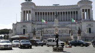 Municipality police man Fabio Grillo directs the traffic standing on a platform in Rome's Piazza Venezia Square.