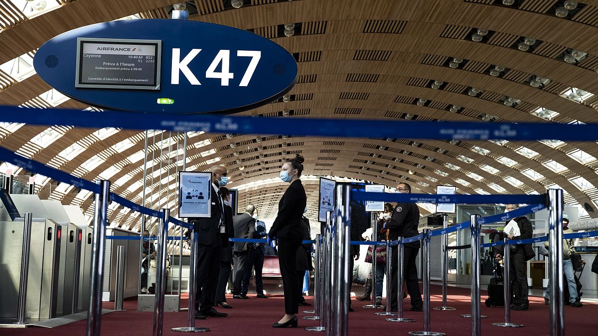 Az Air France földi személyzetének tagjai várják az utasokat a Charles de Gaulle repülőtéren - MTI
