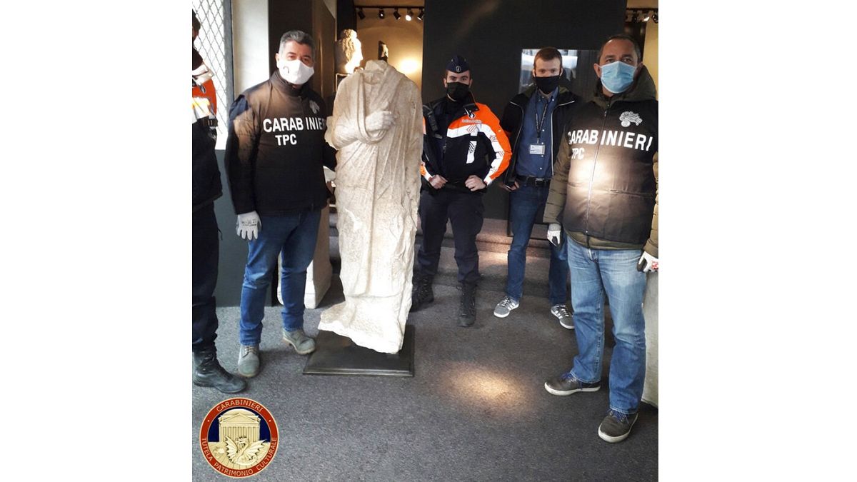 Italian antiquities police the Carabinieri Art Squad with the recovered statue in Brussels