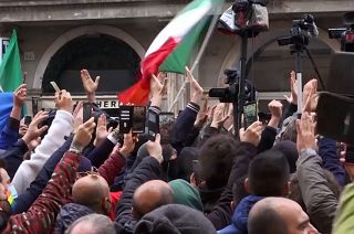 Protesters raising hands, clapping hands and singing Italian national anthem  