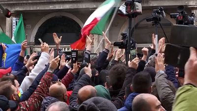 Protesters raising hands, clapping hands and singing Italian national anthem