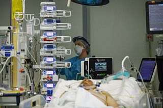 A medical staff member tends to a patient in the COVID-19 intensive care unit at the Pope John XXIII hospital, in Bergamo, Italy, Thursday, March 18, 2021.