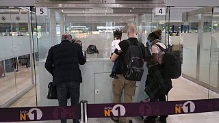 Passengers are checked by French police officers before boarding a flight at Paris Charles de Gaulle Airport in February 2021