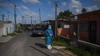 Un sanitario espera antes de hacer un test de covid en un barrio de Montevideo
