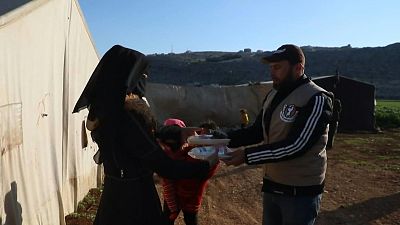 توزيع وجبات طعام على سكان مخيم في إدلب شمال سوريا 