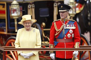 Britain's Queen Elizabeth II, and Prince Philip take a salute as the Guards march past outside Buckingham Palace on June 16, 2012.