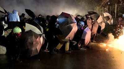 Protesters holding umbrellas as shields