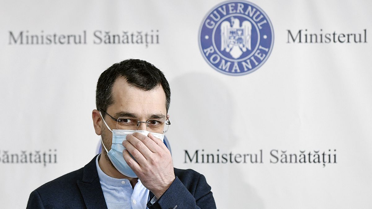 Romania's former health minister Vlad Voiculescu adjusts his mask during a press conference in Bucharest.