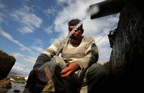 صورة من الارشيف - فلسطيني يملأ زجاجة بالمياه، عند نافورة  بالقرب من مخيم البقعة للاجئين الفلسطينيين في عمان