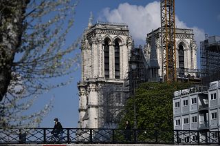A cyclist ride his bike over the Pont de l'Archeveche (Archbishop's Bridge), past the Notre-Dame de Paris cathedral, on April 14, 2021, during the reconstruction work