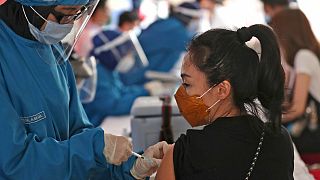 A woman receives a shot of a COVID-19 vaccine at Tanah Abang Market in Jakarta, Indonesia, Wednesday, Feb. 17, 2021. 